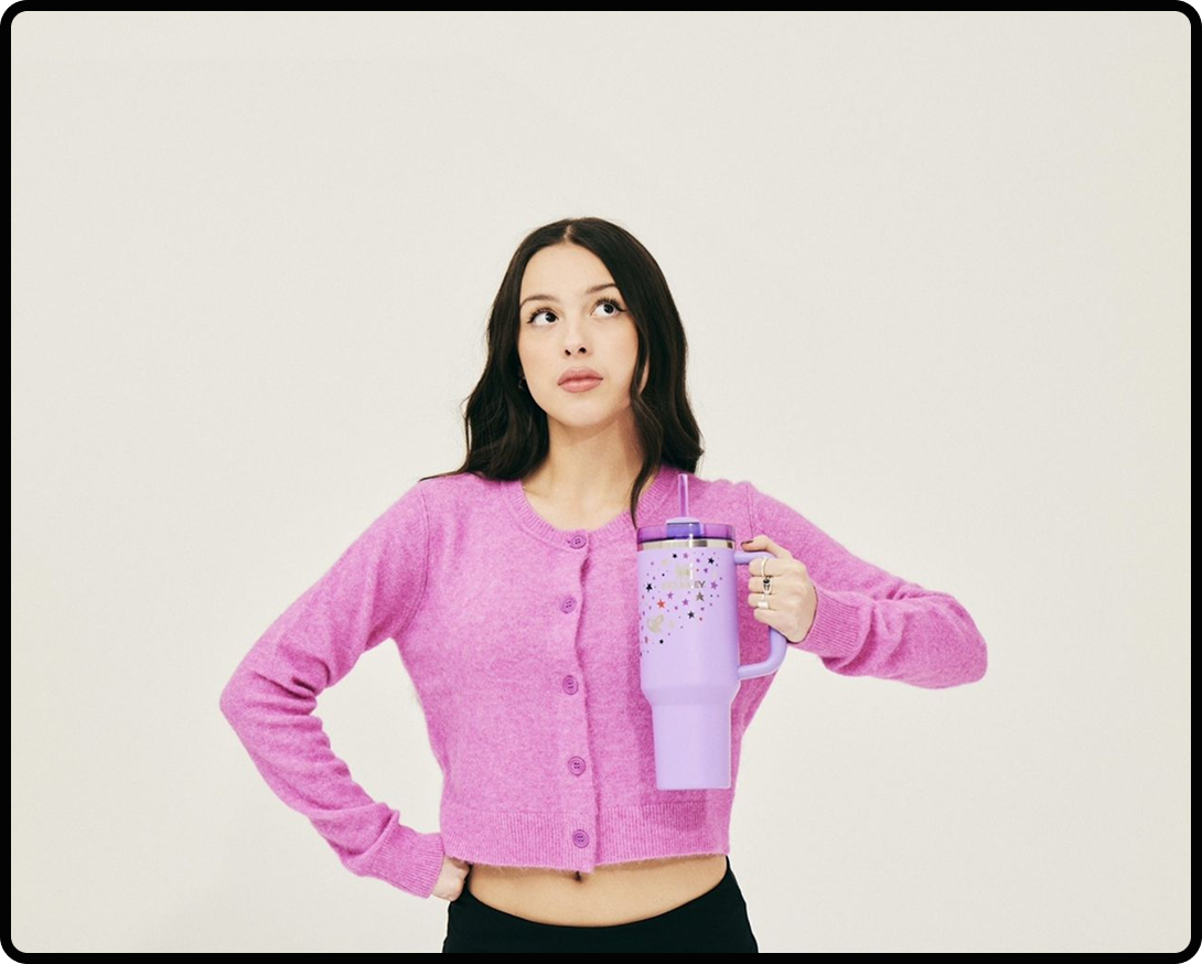 Olivia Rodrigo holding a product from her line of Stanley Cups