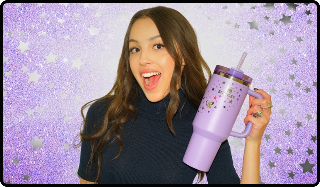 Olivia Rodrigo holding a Stanley Cup from her line while smiling at the camera