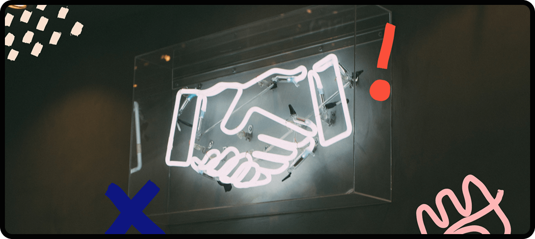 A neon sign of two hands doing a handshake.